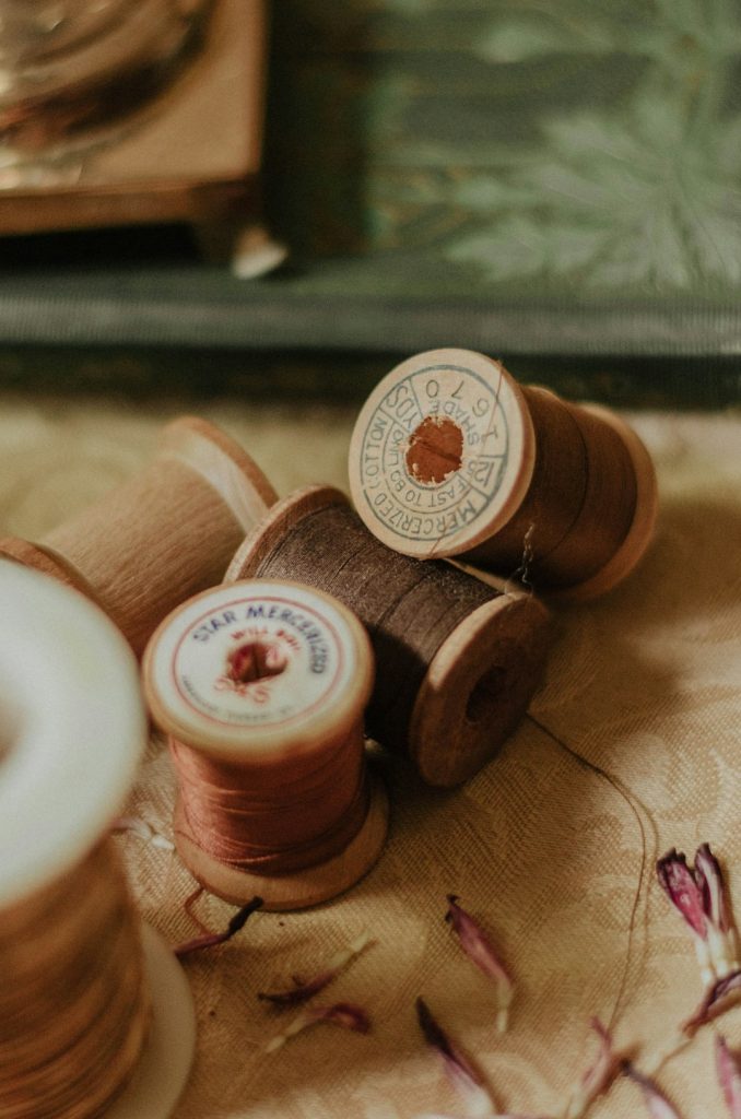 spools-with-threads-on-beige-surface-vclp1ezgng4